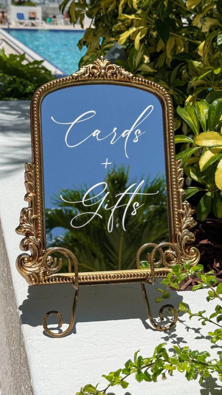 Cards & Gifts Sign rental for a Miami wedding event, displayed on an antique tabletop mirror with a gold frame by Be Extra Miami.